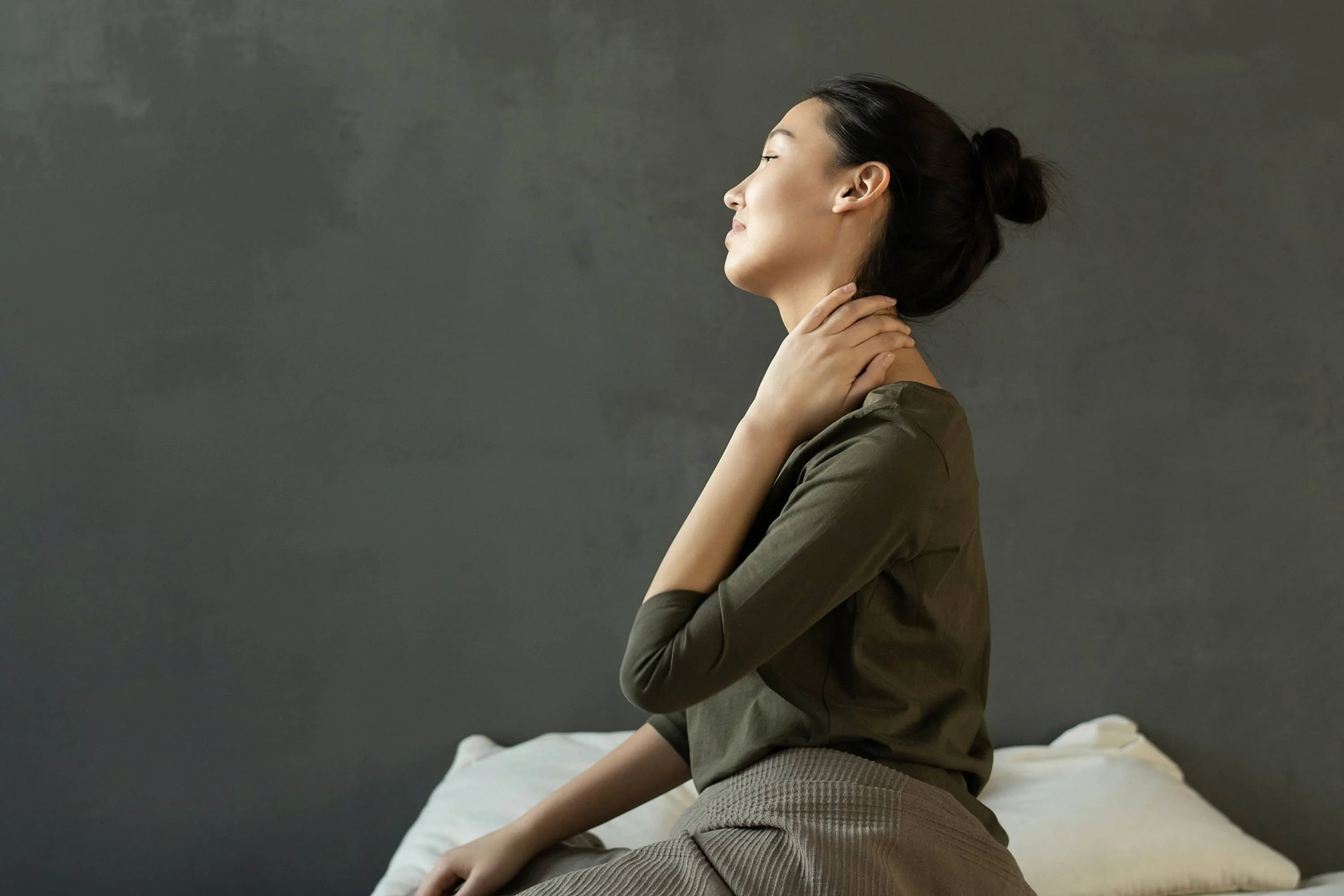 a woman looking into the distance touching her neck